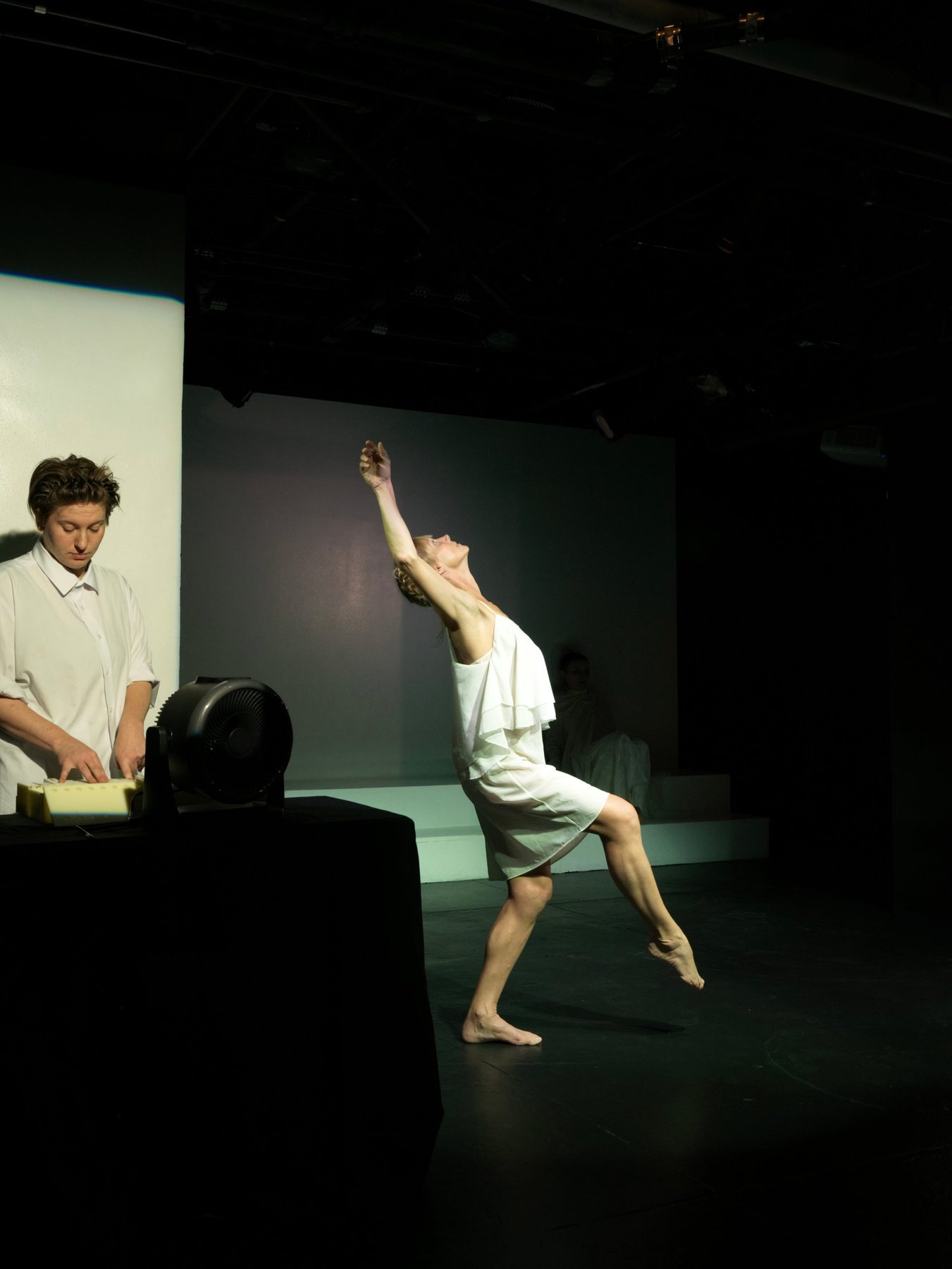 M Dougherty plays the Odor Organ as Emily Pope, dancing in white, arches backward across the stage.
